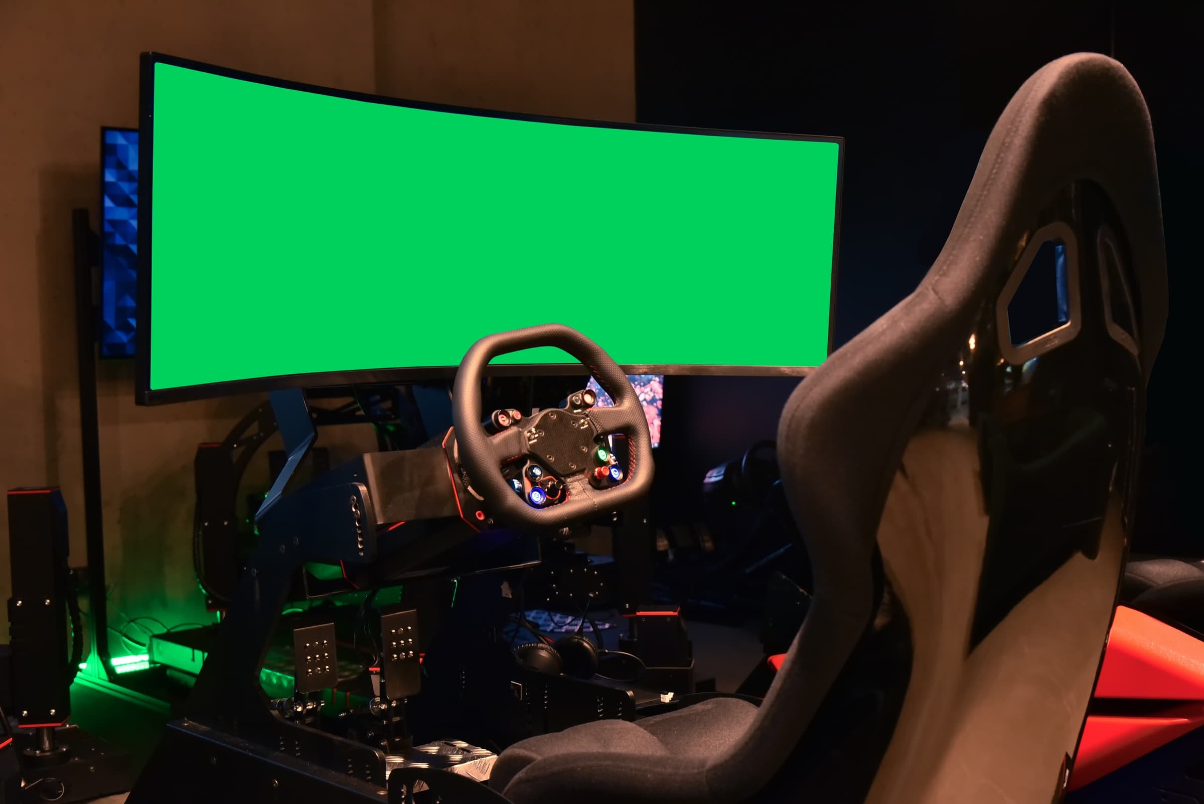 Dark-room sim rig with a formula-style steering wheel, ultrawide monitor, and bucket seat